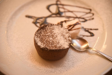 Chocolate muffins with chocolate syrup and ice cream .
