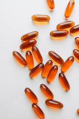 Pile of scattered capsules with medication on white background