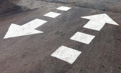 Fototapeta premium Traffic sign white arrows on asphalt road