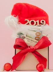 New year gift box with dollars and inscription 2019 on a pink background