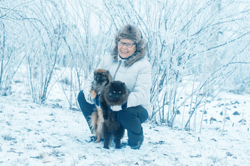 Woman with dog Pekingese and cat in winter park