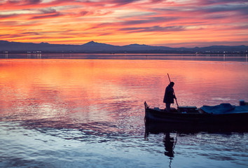 Boat ride in the Sunset of the calm waters of the Albufera de Valencia, Spain.