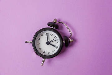 Ringing twin bell vintage classic alarm clock Isolated on purple violet pastel colourful...