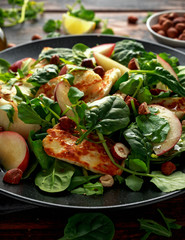 Grilled Halloumi Cheese salad with peach fruit, nuts and spinach, arugula mix. healthy food
