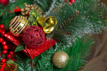 A Christmas red ball hangs on the background of a clock. It's time for a new year. Multicolored glare and brilliance. bell