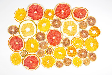 Dried slices of various citrus fruits on white background.