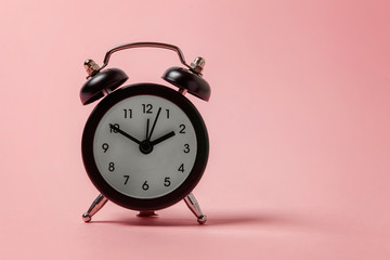 Ringing twin bell vintage classic alarm clock Isolated on pink pastel colourful background. Rest...