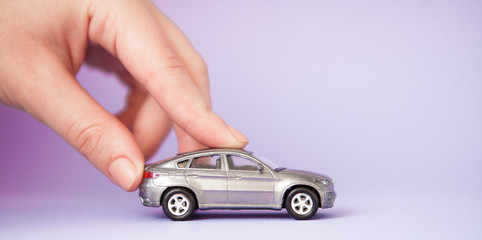 Toy child car in woman's hand. Purchase insurance bank loan travel where to go trip journey...