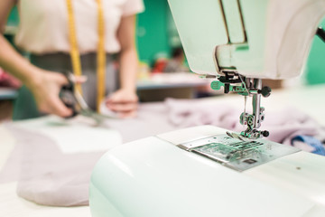 Sewing workshop. Seamstress at work. Marking and cutting fabric.