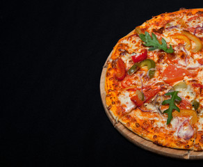 Pizza on a wood board with a copy of the place on a black background