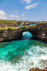 Fototapeta na wymiar Stone arch over the sea. Beautiful and clear turquoise water at Broken Beach in Nusa Penida, Indonesia.