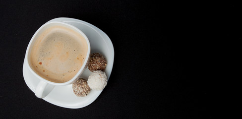 Coffee cup, beans, chocolate and macaroons on old kitchen table. Top view with copyspace for your text