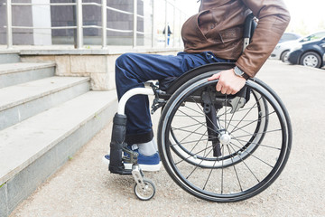 Man in wheelchair in front of stairs.