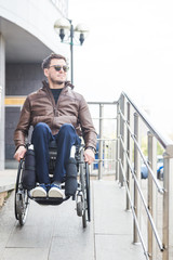 Man in a wheelchair use a wheelchair ramp.