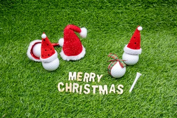 Schilderijen op glas Golf Christmas with golf ball and Santa Claus hat and tee on green grass  © thaninee