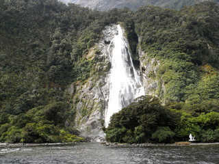 Fototapeta na wymiar Milford Sound,New Zealand-March 21, 2010: A waterfall at Milford Sound