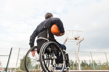 Young man in a wheelchair playing basketball.
