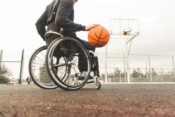 Young man in a wheelchair playing basketball.