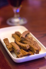 Rectangular white plate with a beer snack with rye flour crackers.