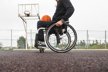 Young man in a wheelchair playing basketball.