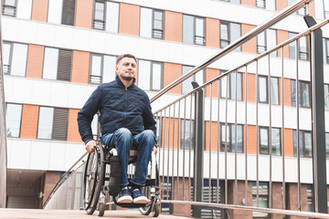 Man in a wheelchair use a wheelchair ramp.