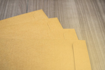 A brown envelope on a wooden floor surface, space for copy.