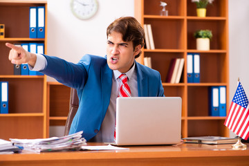 Young handsome politician sitting in office 