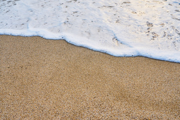                               White foam on a sandy beach. Copy space. 