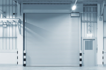 Obraz premium Roller door or roller shutter. Also called security door or security shutter with automatic system. For protection industrial building i.e. factory, warehouse, hangar, workshop, store, hall or garage.