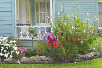 Fototapeta na wymiar Colorful flowers in front of classic wooden villa porch.