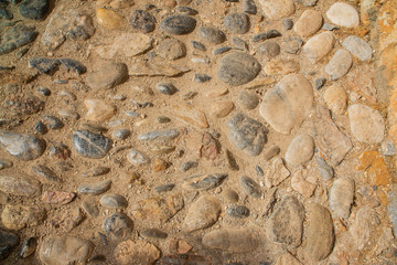 Old beige stone wall background texture close up