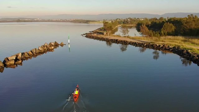 Several different shots of someone paddling a Kayak on a lake in Berekely, NSW, Australia