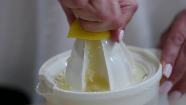 Side view of hands using a juicer to gather fresh lemon juice