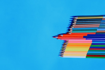 Multicolour pencils isolated on blue background.Close up several colors.
