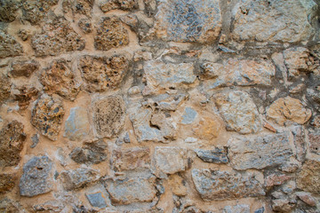Old beige stone wall background texture close up