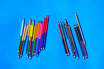 Multicolour pencils isolated on blue background.Close up several colors.