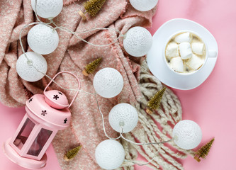 Fototapeta na wymiar Warm, cozy winter scarf, lightbox on pastel and cup of coffee with marshmallow pink background. Christmas, New Year concept flat lay. hello winter title