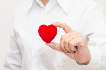 Woman's hand holding a heart shape