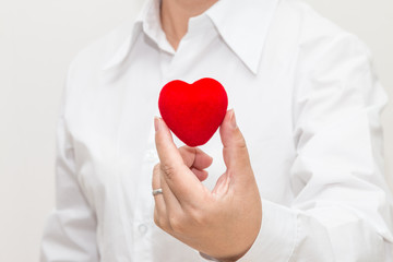 Woman's hand holding a heart shape