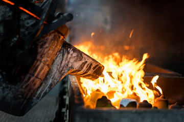 Fototapeta premium Molten metal casting, operator pouring metal casting parts from ladle in factory