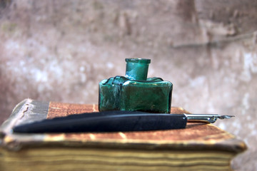 Old inkwell and quill pen. Vintage background. Free space for text.