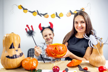 A mother and her daughter carving pumpkin together
