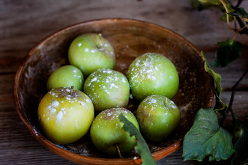  inside of wooden basket green apples ready to be prepared on cake with a little flour on top