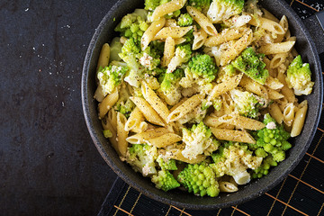 Penne pasta with cabbage romanesco on black table. Vegetarian food. Italian menu. Top view. Flat lay