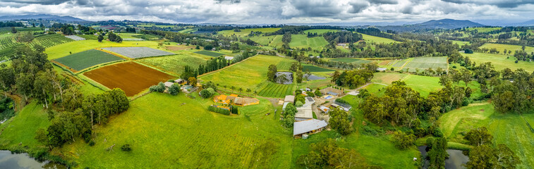 Fototapeta na wymiar Wide aerial panorama of fields, meadows, and pastures - rolling landscape of Wandin, Melbourne, Australia