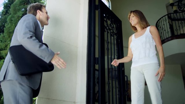 Male Caucasian real estate agent meeting female home owner to discuss sale of property RED EPIC