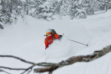 Woman skier free rider goes down on powder snow in the mountains in a snowfall