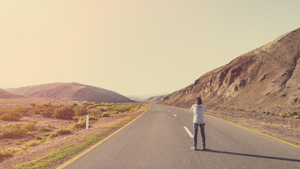 Fototapeta premium Photographer traveler on the road in the mountains