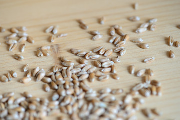 Scattered wheat grains on wooden background close up