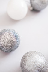 White Christmas background. Glossy silver and glitter decoration balls. Minimalist style. Copyspace for text, overhead